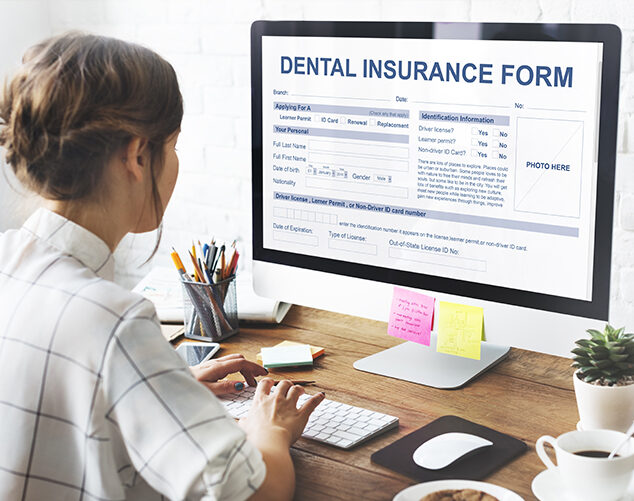 Woman Filling Out a Dental Insurance form on a Computer